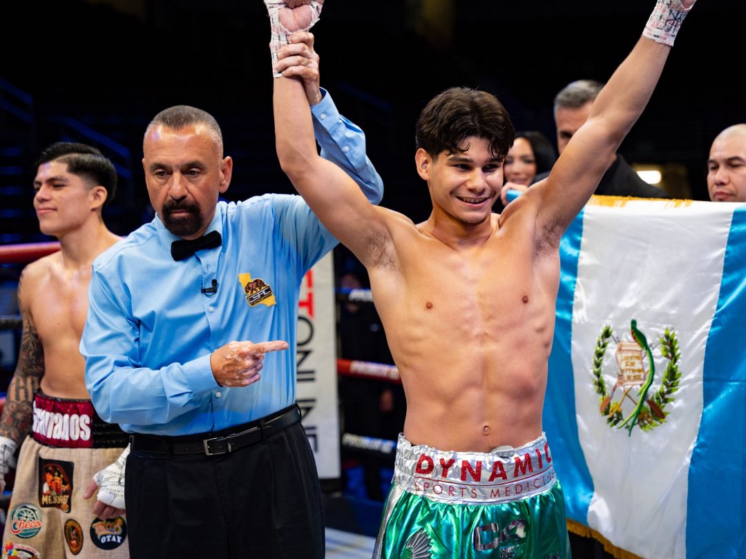 Referee raising Amador Mendez's hand in victory